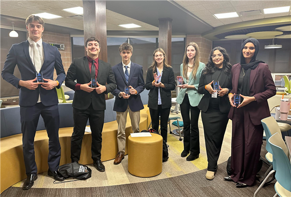  DECA winners holding their trophies